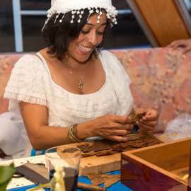 Zigarrenrollerin an ihrem Arbeitstisch bei einem Firmen-Event