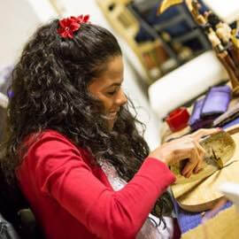 Zigarrenrollerin schneidet das Ende einer neu gerollten Zigarre