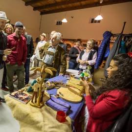 Besucher beobachten eine Zigarrenrollerin bei der Arbeit