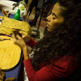 Foto Zigarrenrollerin dreht ein Tabkblatt um eine neue Zigarre