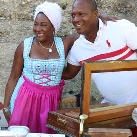 Zigarrendreherin mit Kunde und einer Kiste voller Zigarren auf Kuba