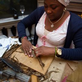 Das erste Tabakblatt wird um eine neue Zigarre gewickelt bei der Herstellung