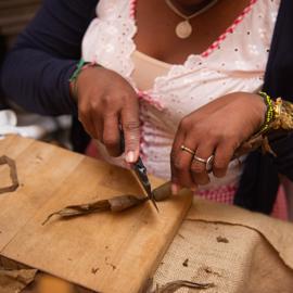 Von einer Zigarre wird die Spitze abgeschnitten von einer Zigarrenrollerin