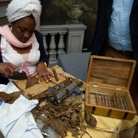 Foto von einem Tische einer Zigarrenrollerin bei der Arbeit mit allen Werkzeugen 