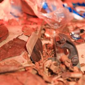 Foto vom Tisch einer Zigarenrollerin mit Tabakblättern und Werkzeugen