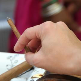 Brennende dünne Zigarre in der Hand eines Rauchers