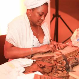 Kubanische Zigarrendreherin beim drehen einer Zigarre bei einem Event