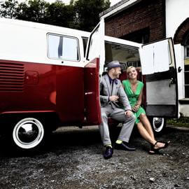 Pärchen sitzt in der offenen Seitentür des Oldtimer VW Bulli T1